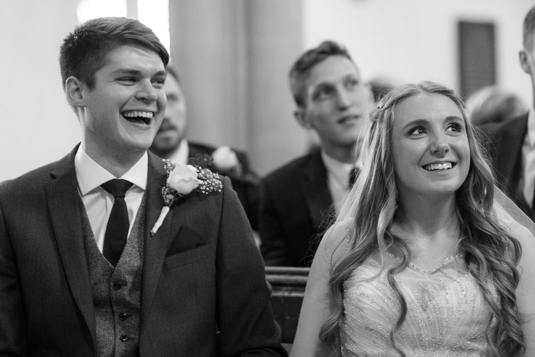 bride and groom laugh during the service at St Michael's church in Camberley