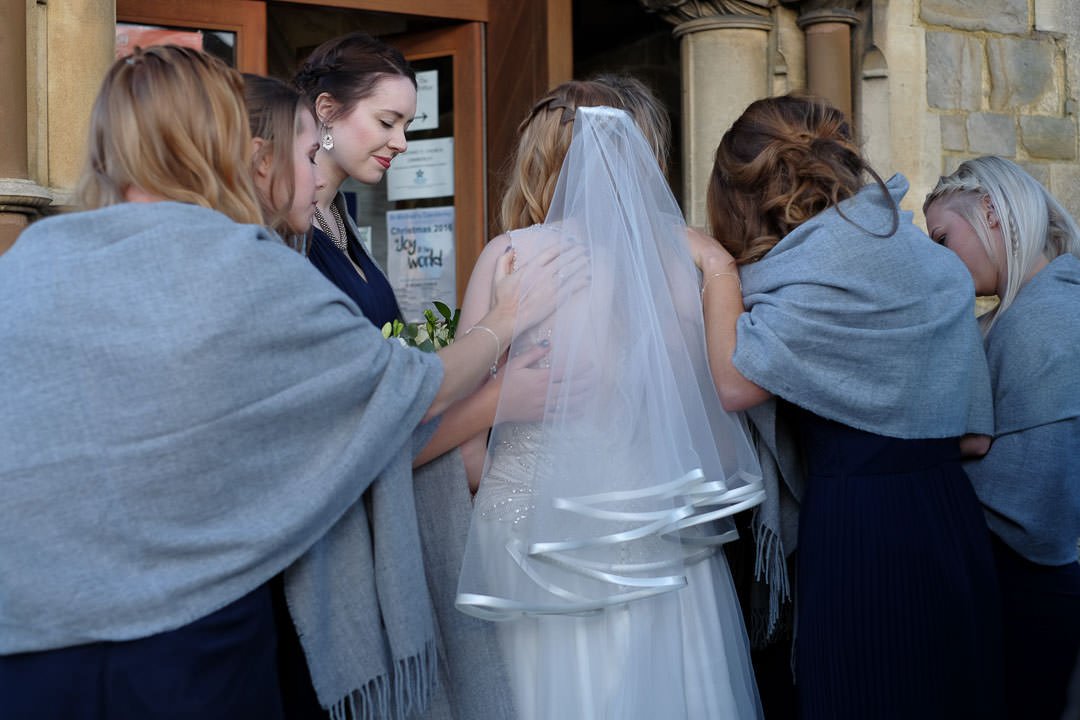 bridesmaids pray with the bride at St Michael's church in Camberley