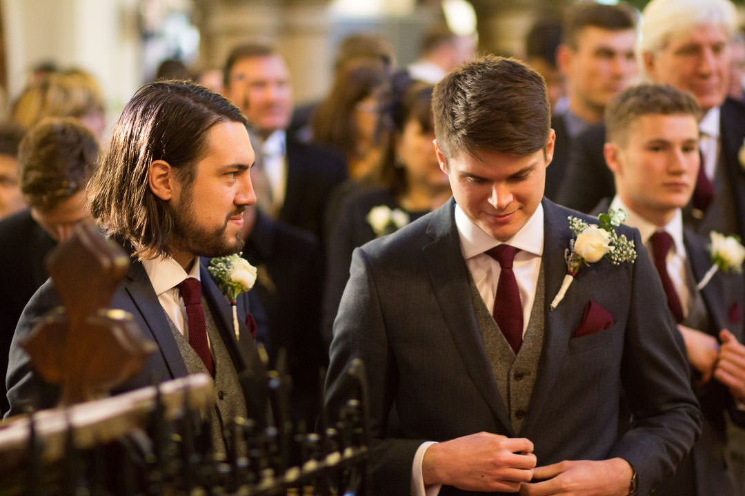 best man watches the groom before the ceremony at St Michael's church in Camberley