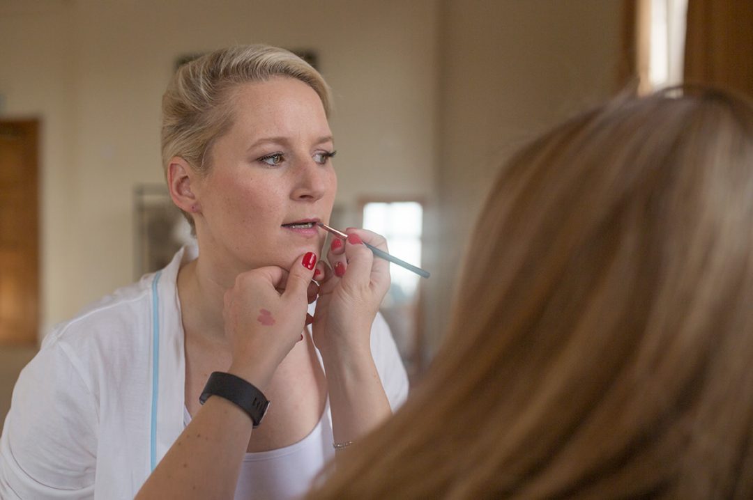 Bride having lipstick applied by the make-up artist at the Elvetham Hotel 