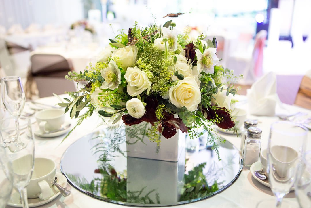 white wedding table floral arrangement on mirror at the Village Hotel wedding Fair