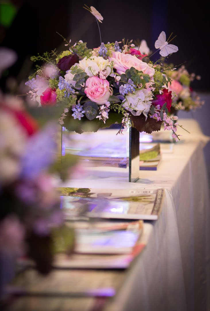 Wedding flower arrangement in mirrored box vase with silk butterflies At the Village Hotel wedding Fair