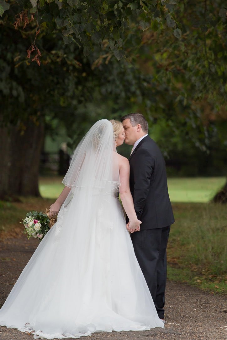Groom kisses the bride at Badgemore Park in Berkshire
