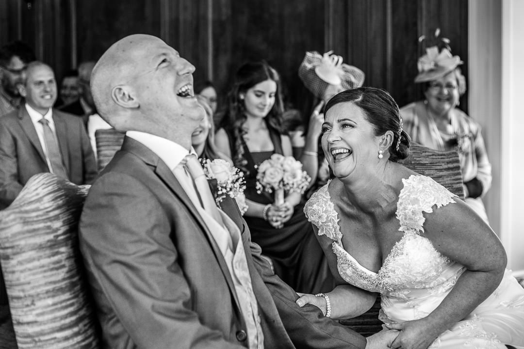 Black and white photo of the bride and groom laughing during the ceremony at Barnett Hill Hotel