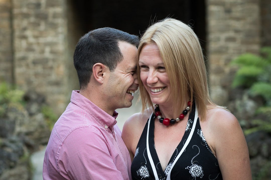 engaged couple laugh together during their pre-wedding photo session at Guildford Castle