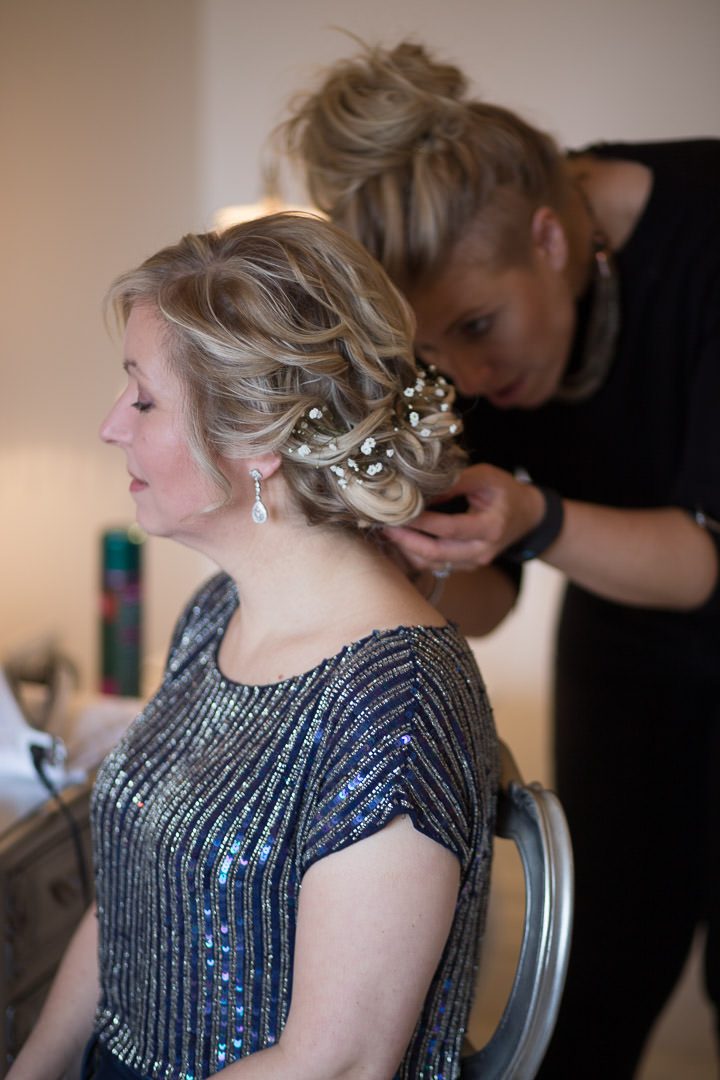 the bride has gypsophilia put into her hair by the hairdresser