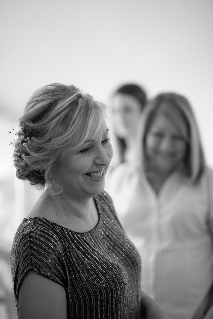 the bride smiles as her friend stands behind watching her