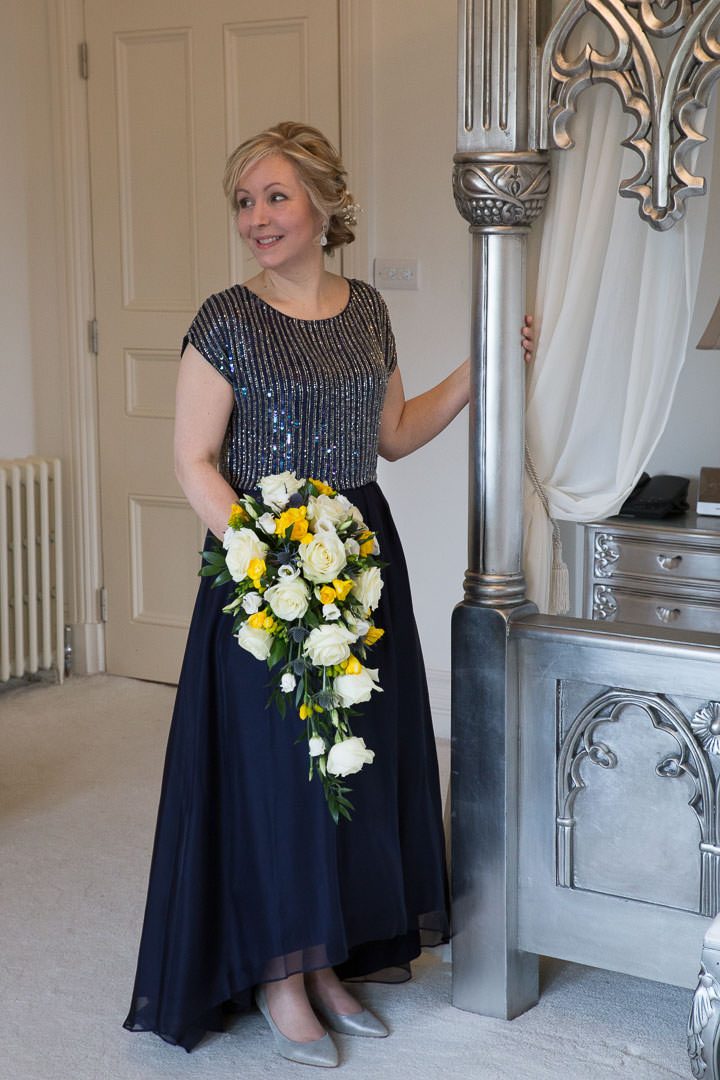 the bride poses and holds her bouquet in Room 1
