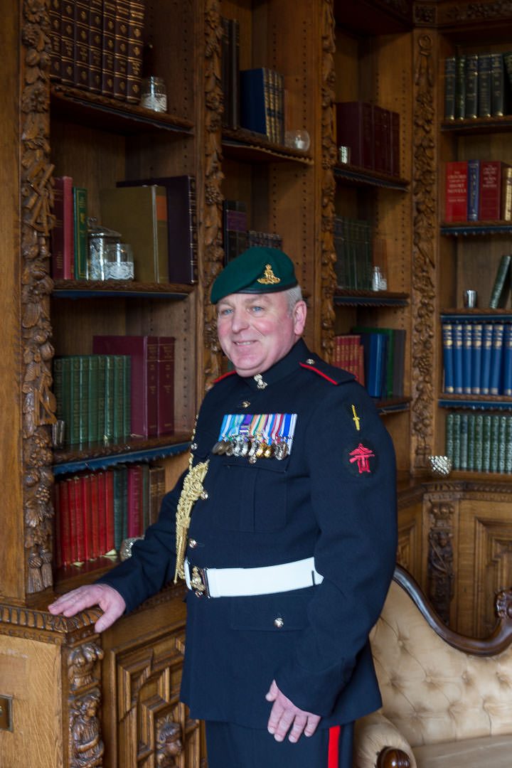 the military groom poses in the library