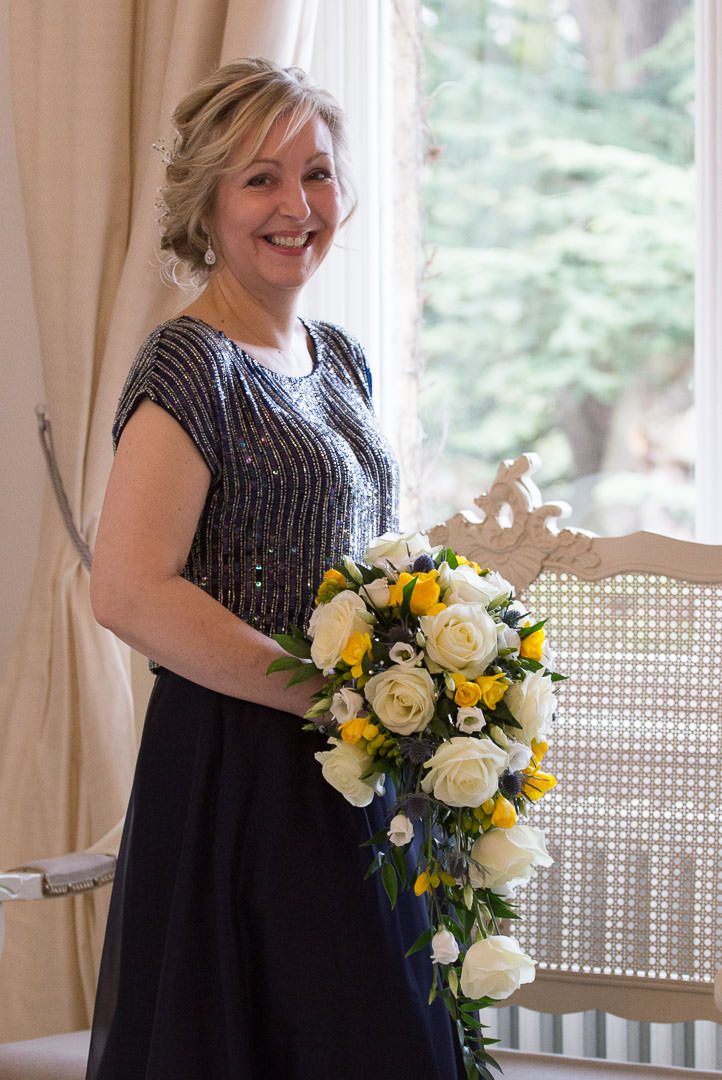 the bride wearing navy blue, poses and holds her wedding bouquet