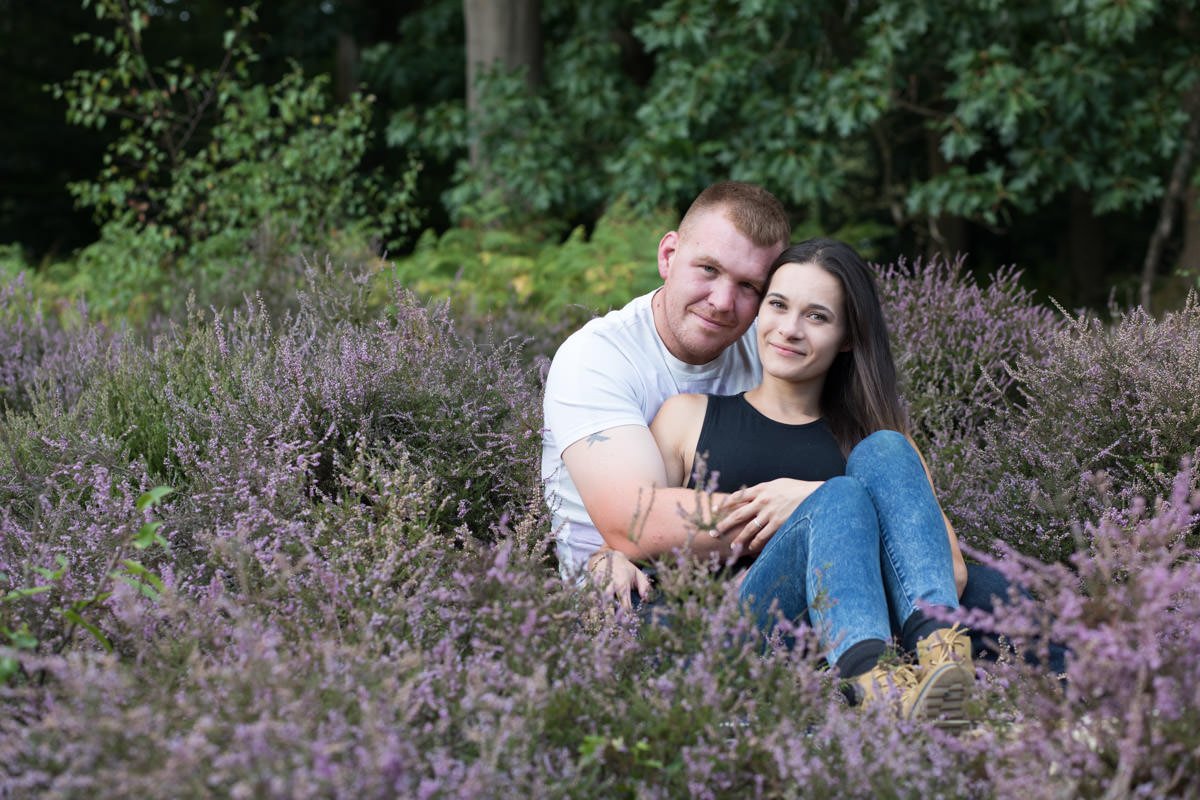 young couple sit together in the pink heather