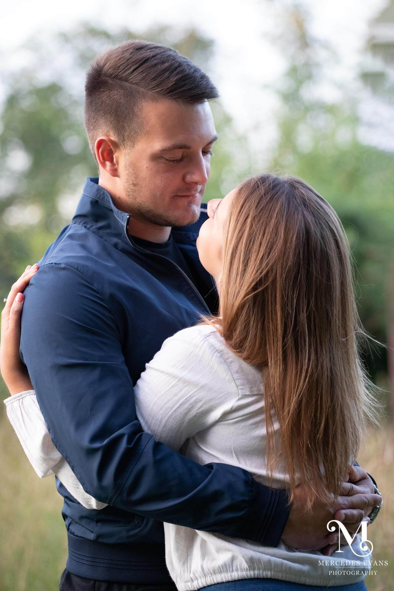 young couple embrace and look at each other in the countryside