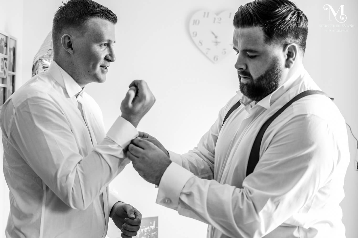 The groomsmen help each other with cufflinks