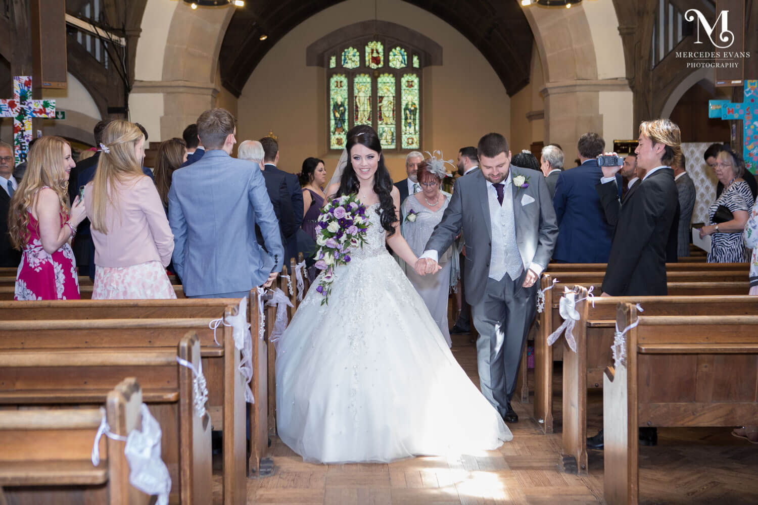 The bride and groom walk back down the aisle after their wedding ceremony at St Andrew's church in Frimley