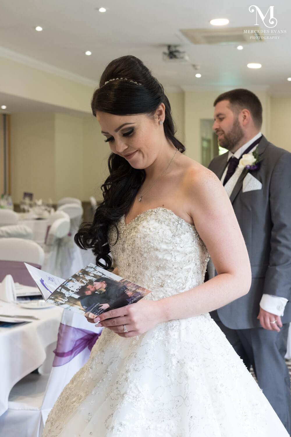 the smiling bride looks at her personalised wedding magazine from Wedition