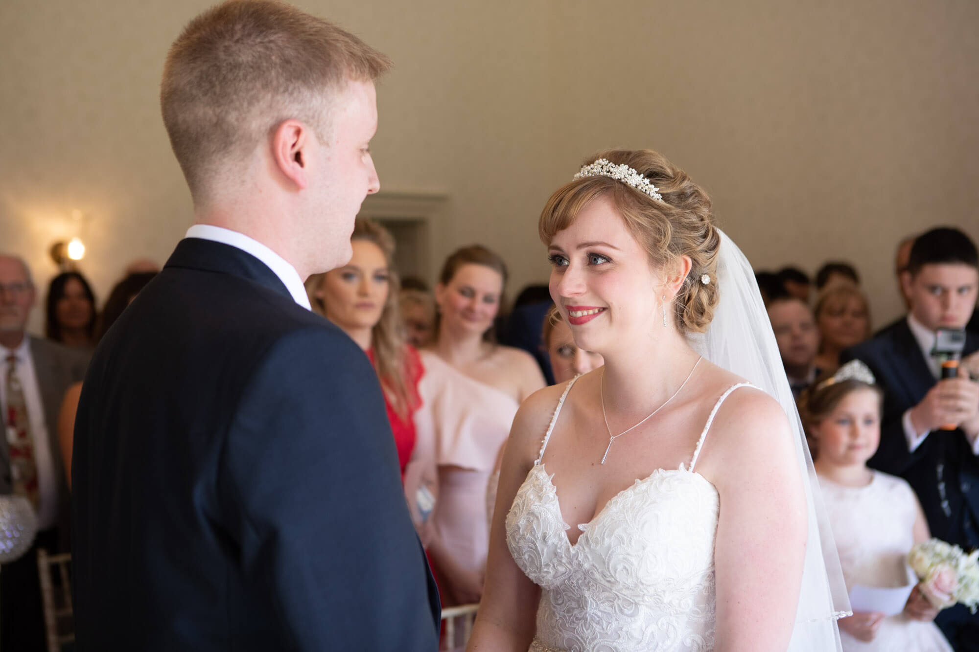 the bride looks smilingly at her groom as they say their wedding vows