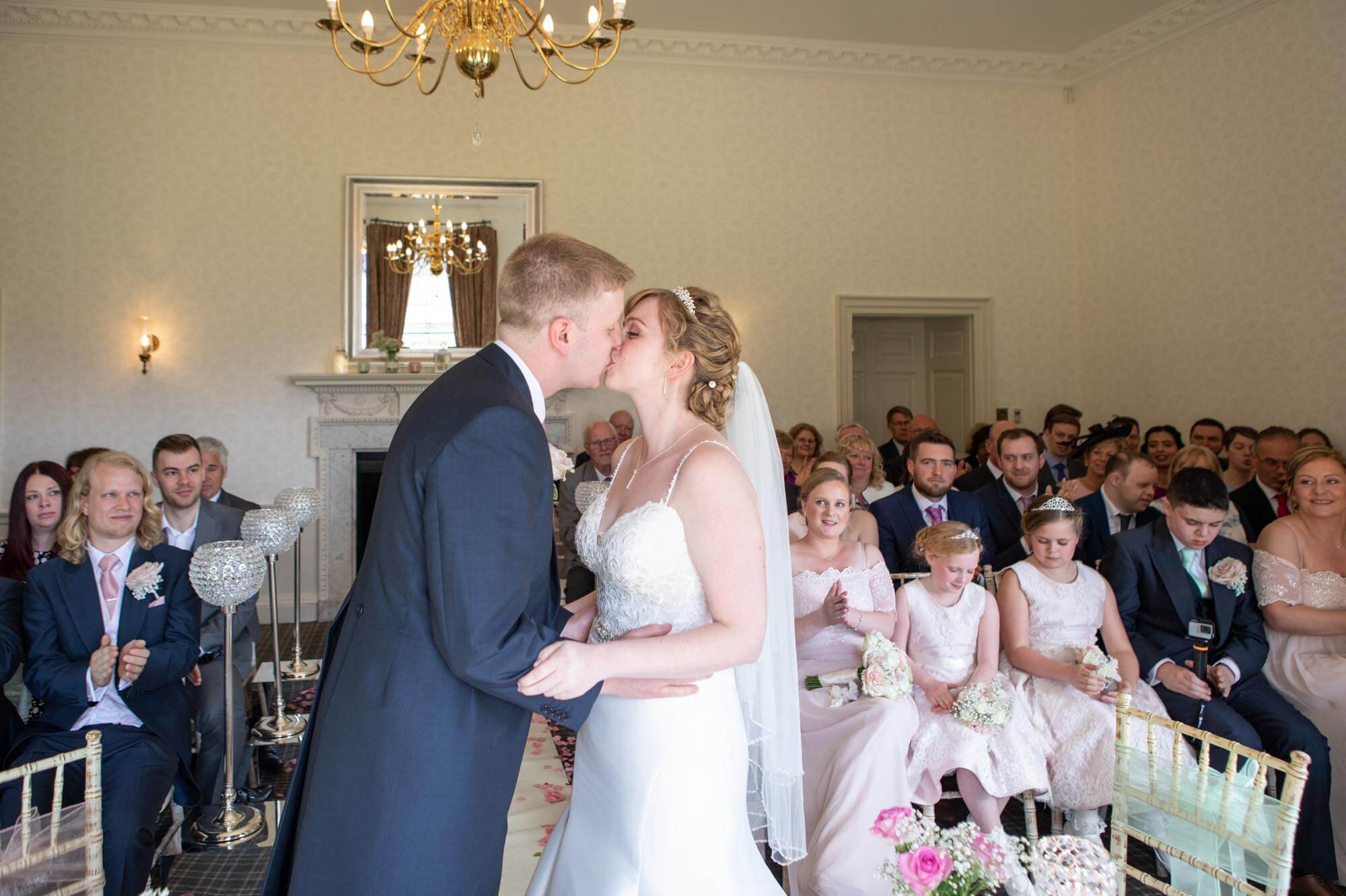 bride and groom kiss during the wedding ceremony at highfield park