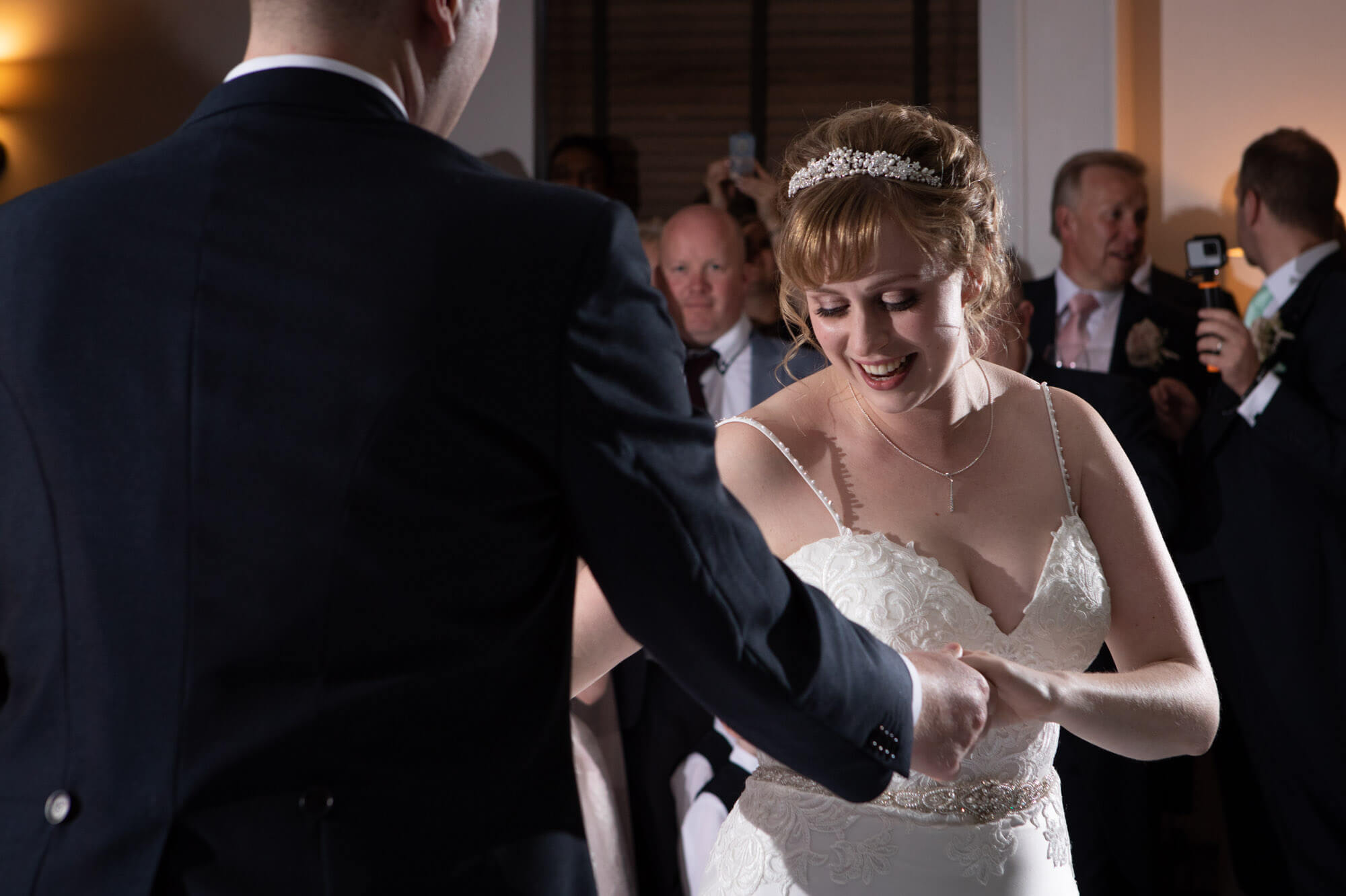 The bride and groom enjoy their first dance together as their guests watch