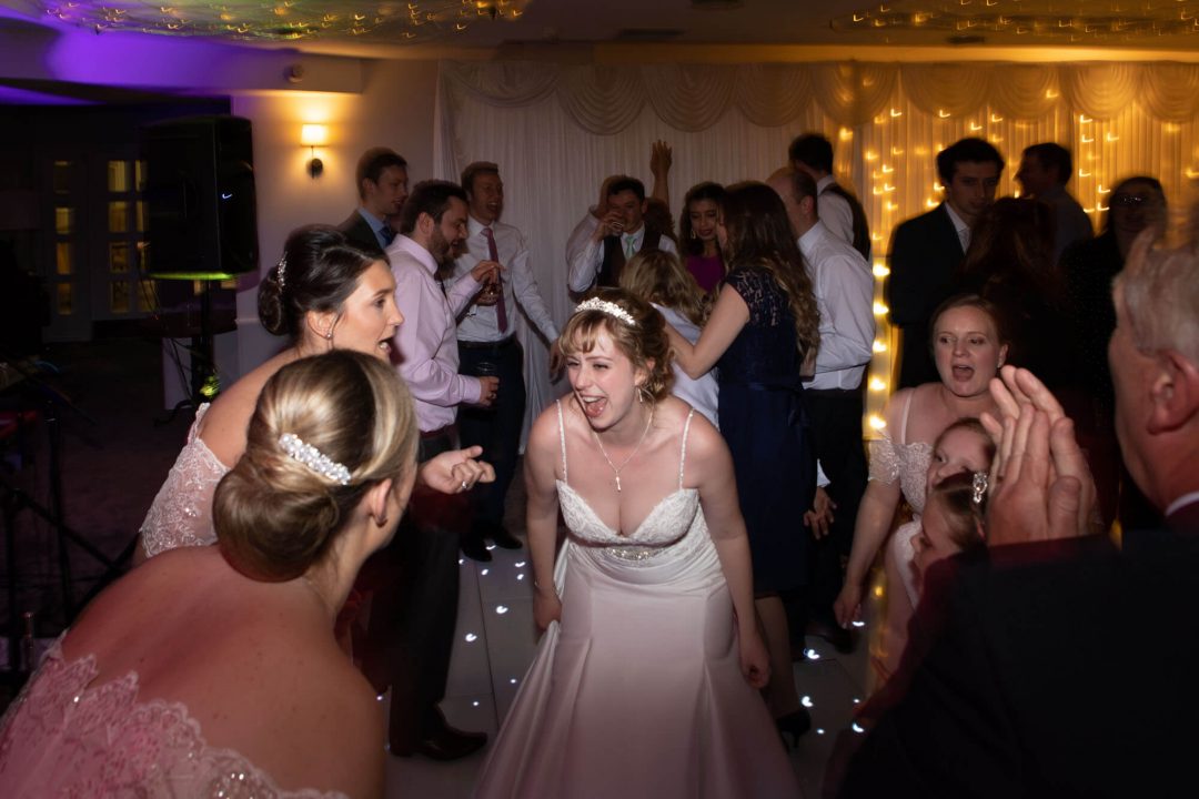 The bride and bridesmaids dance and laugh together as the party gets under way