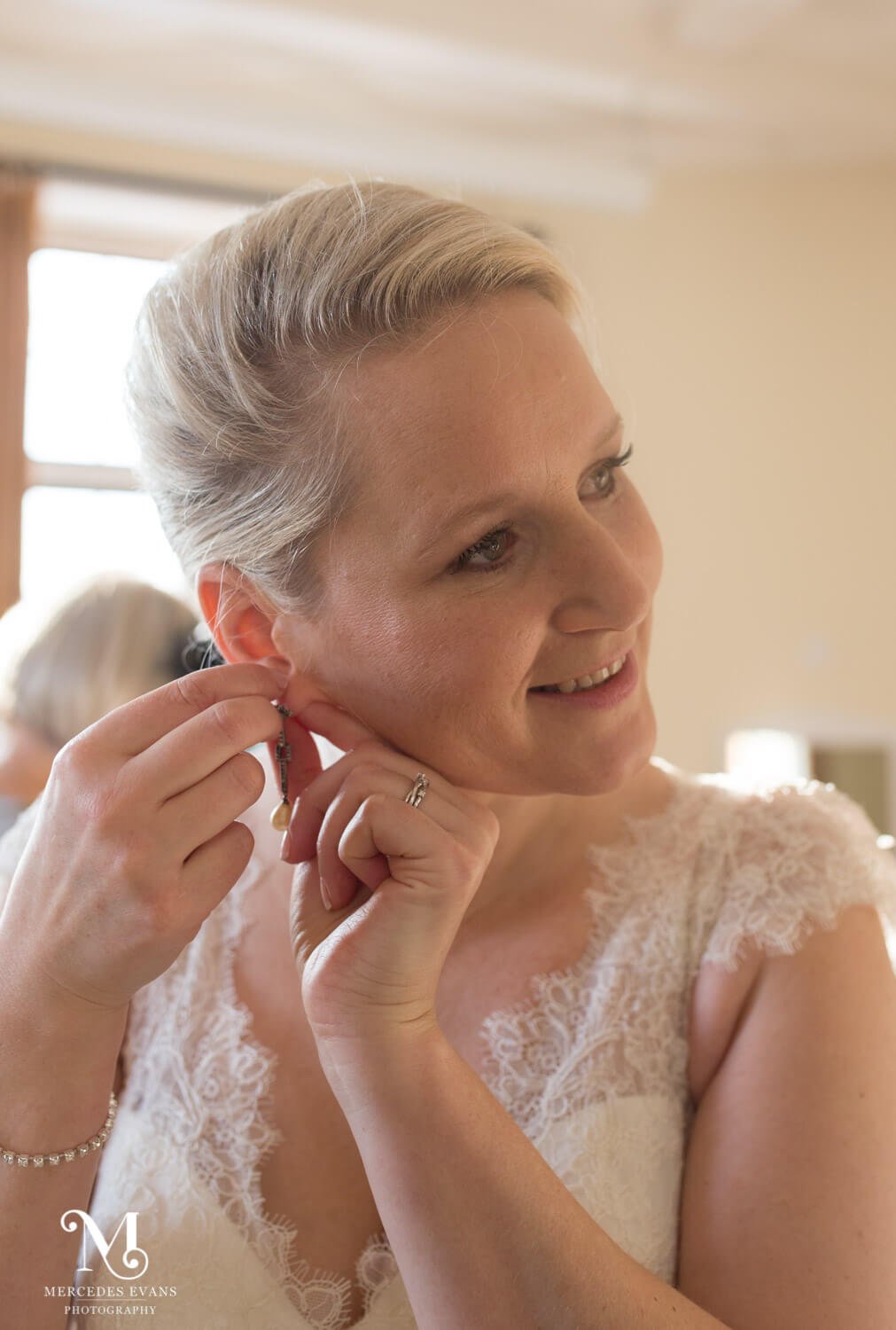 The bride puts on her earrings at the Elvetham