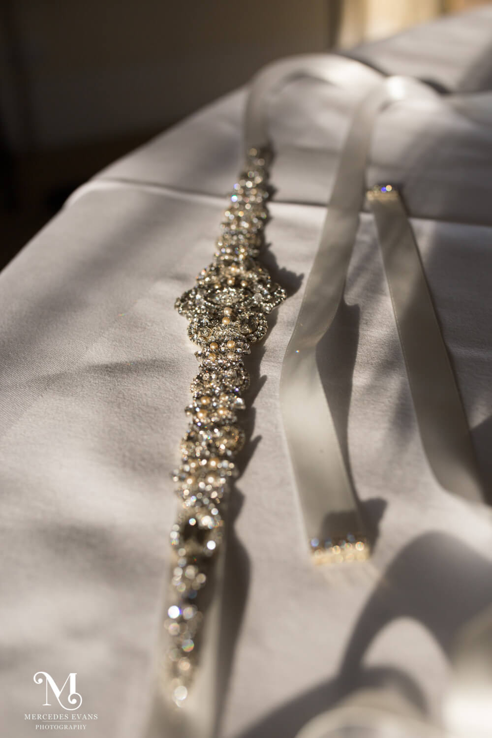 the bride's diamante belt sparkles in the sunshine