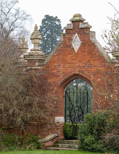 An archway in the brick wall surrounding the gardens at the Elvetham Hotel