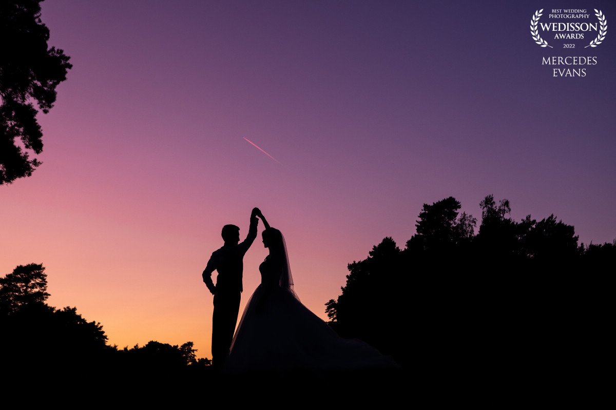 silhouette of bride and groom dancing with purple and orange sunset at a Pine Ridge Golf course wedding