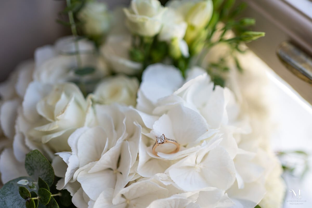 diamond engagement ring nestled in white hydrangea bouquet