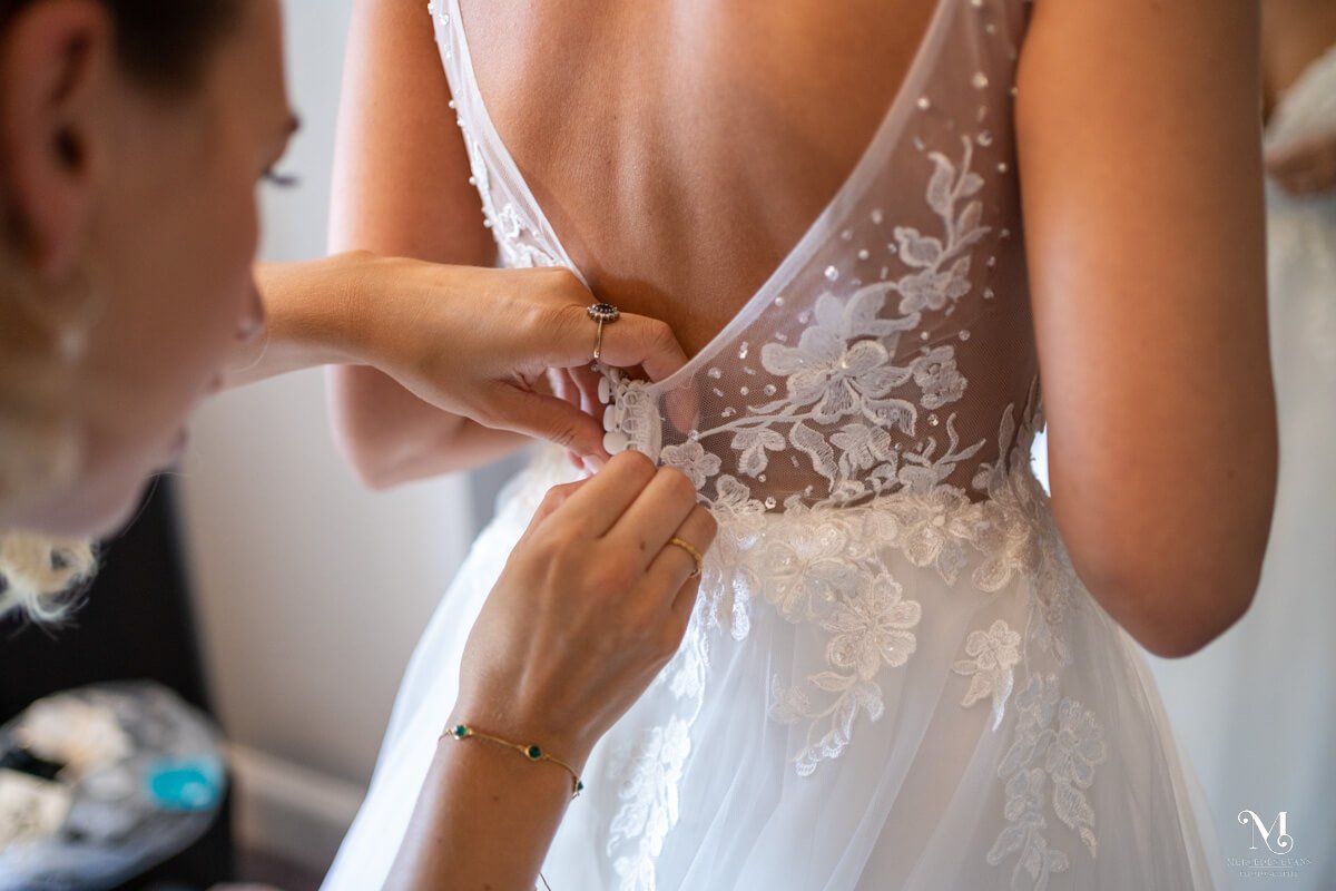 detail of the bride's dress buttons being done up