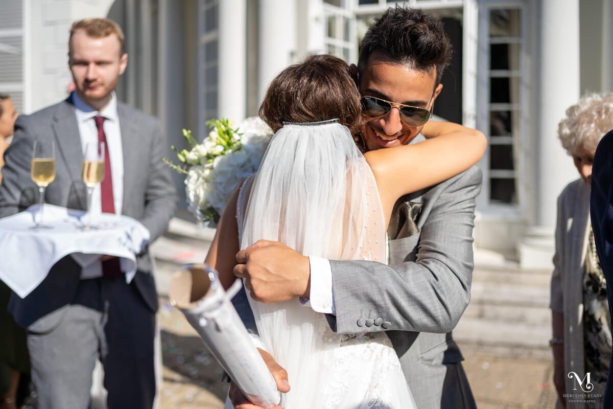 the best man greets the bride with a hug