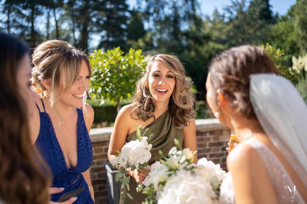 the bridesmaids laugh with the bride during the drinks reception