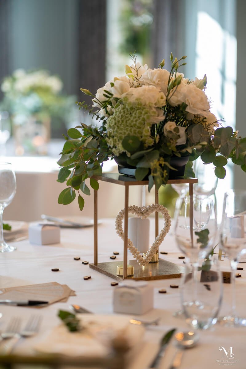 white and green foliage with gold lanterns on the wedding breakfast tables