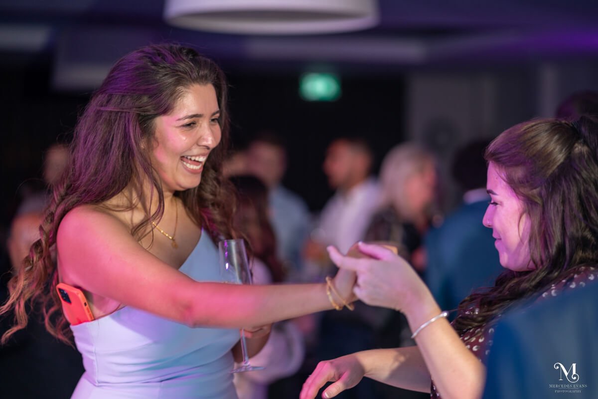 female wedding guests dance and laugh together