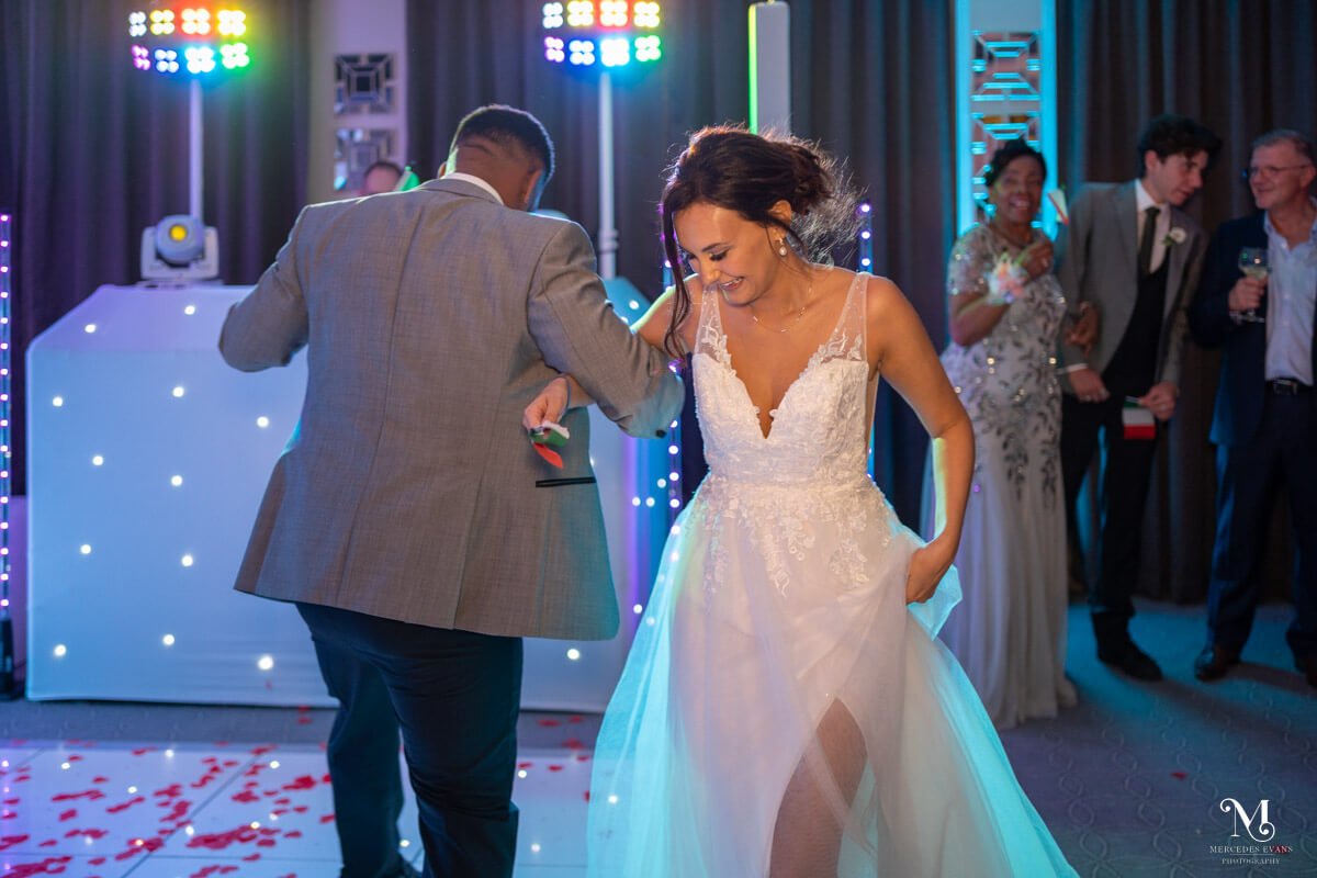 the bride and groom swing each other round on the dance floor in the garden suite at gorse hill hotel