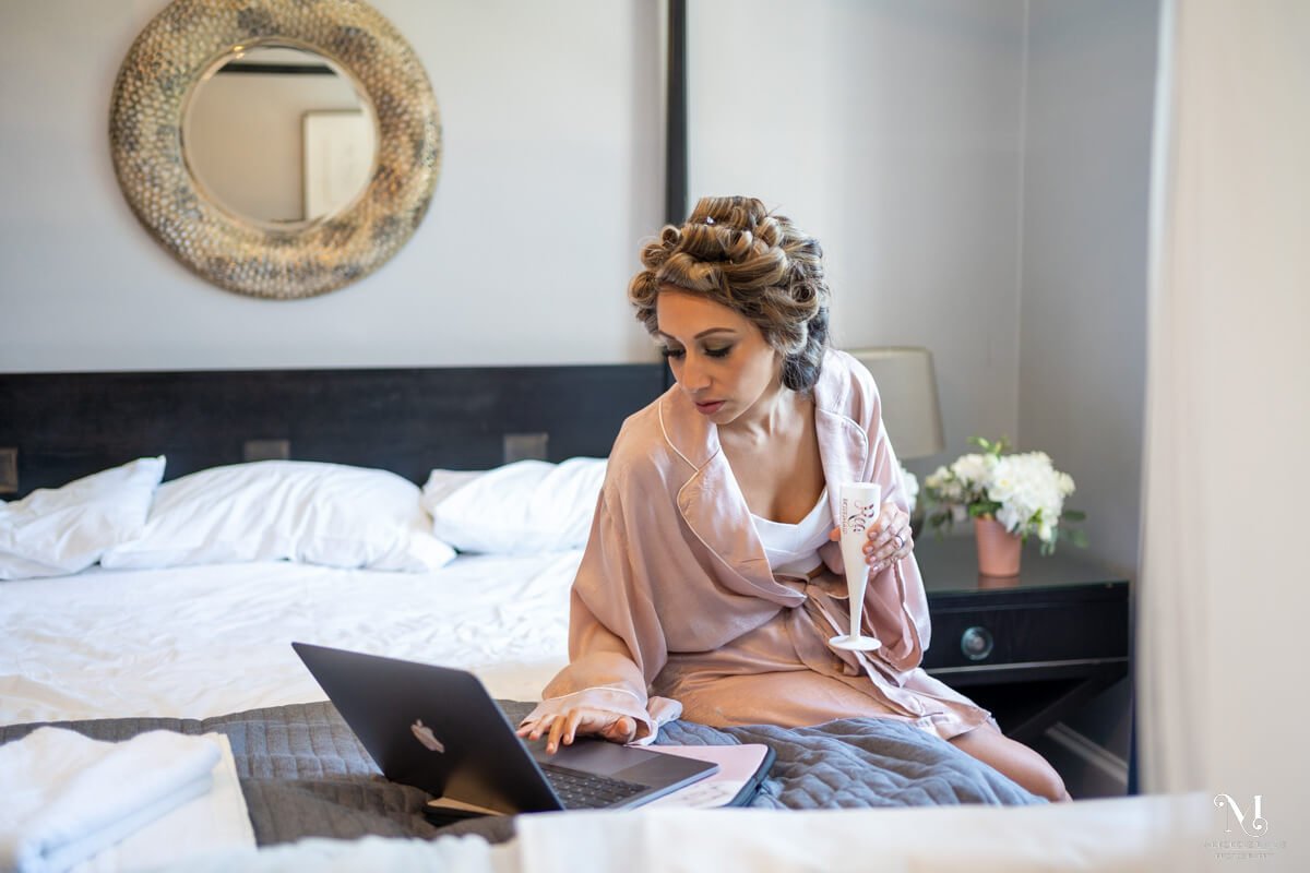 woman looks at laptop on the bed