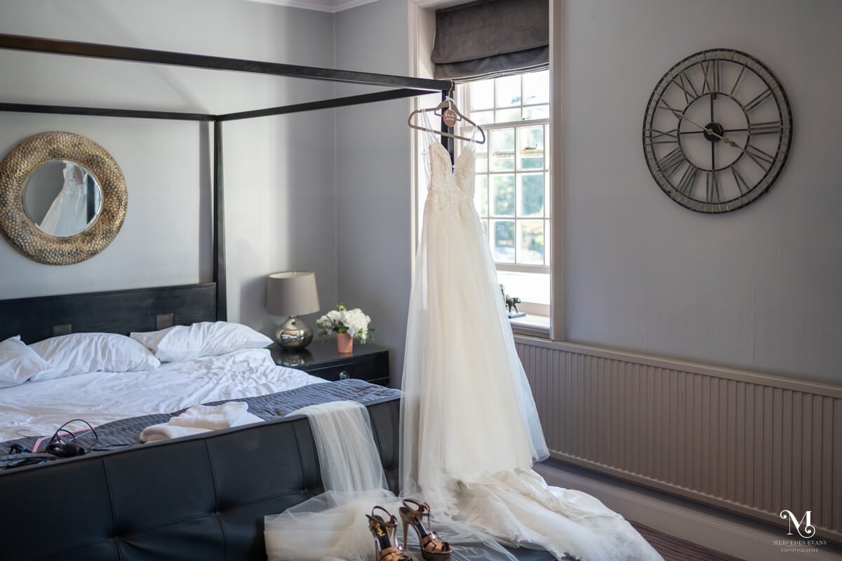 junior suite at Gorse Hill Hotel with the bride's dress hanging from the modern four poster bed