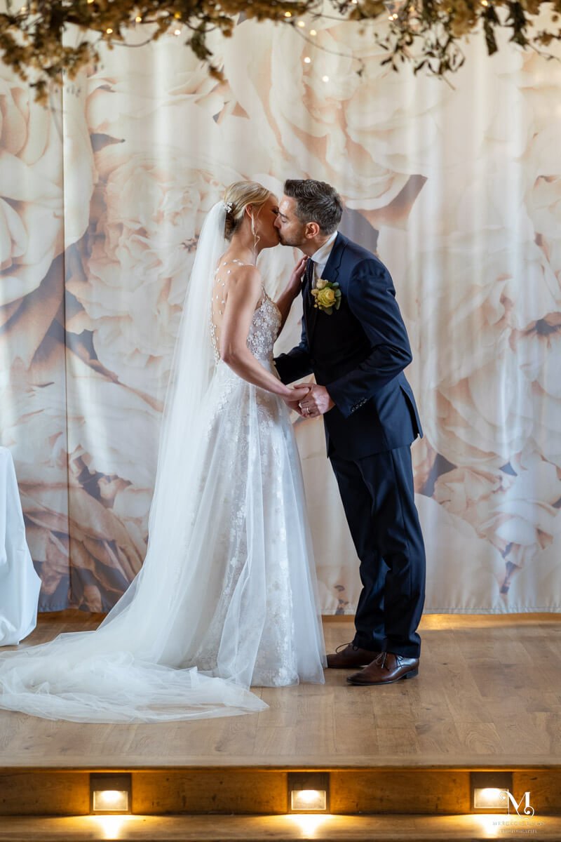 the bride and groom share their first kiss after they are married
