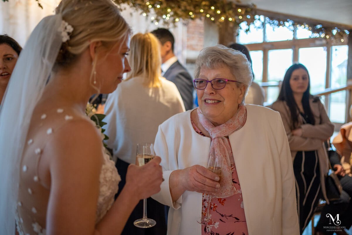 the bride chats with one of her older guests during the wedding drinks reception