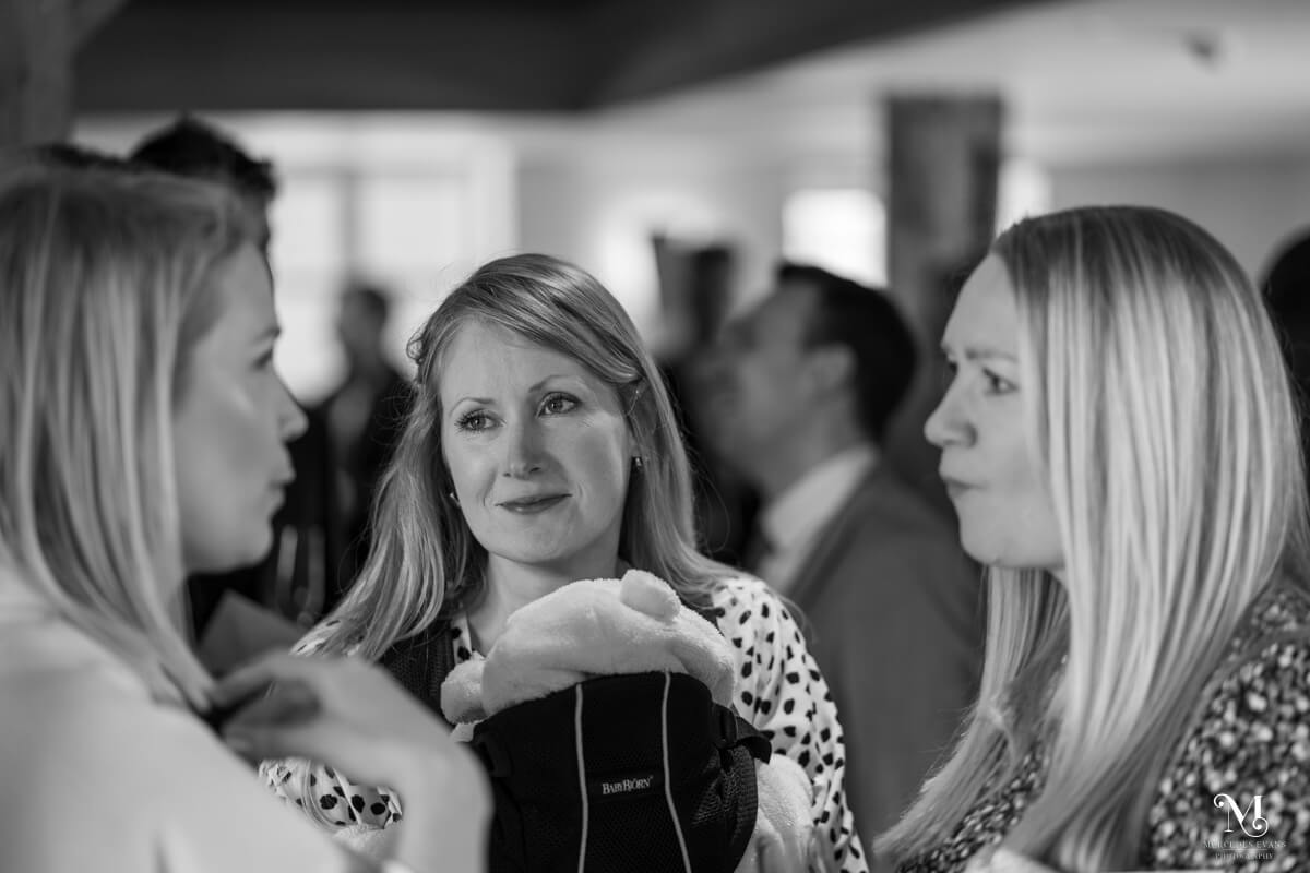 some female wedding guests talk together during the drinks reception