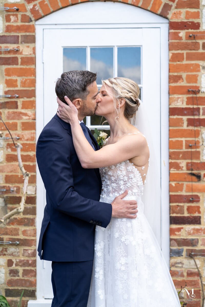 the bride and groom kiss infront of a doorway