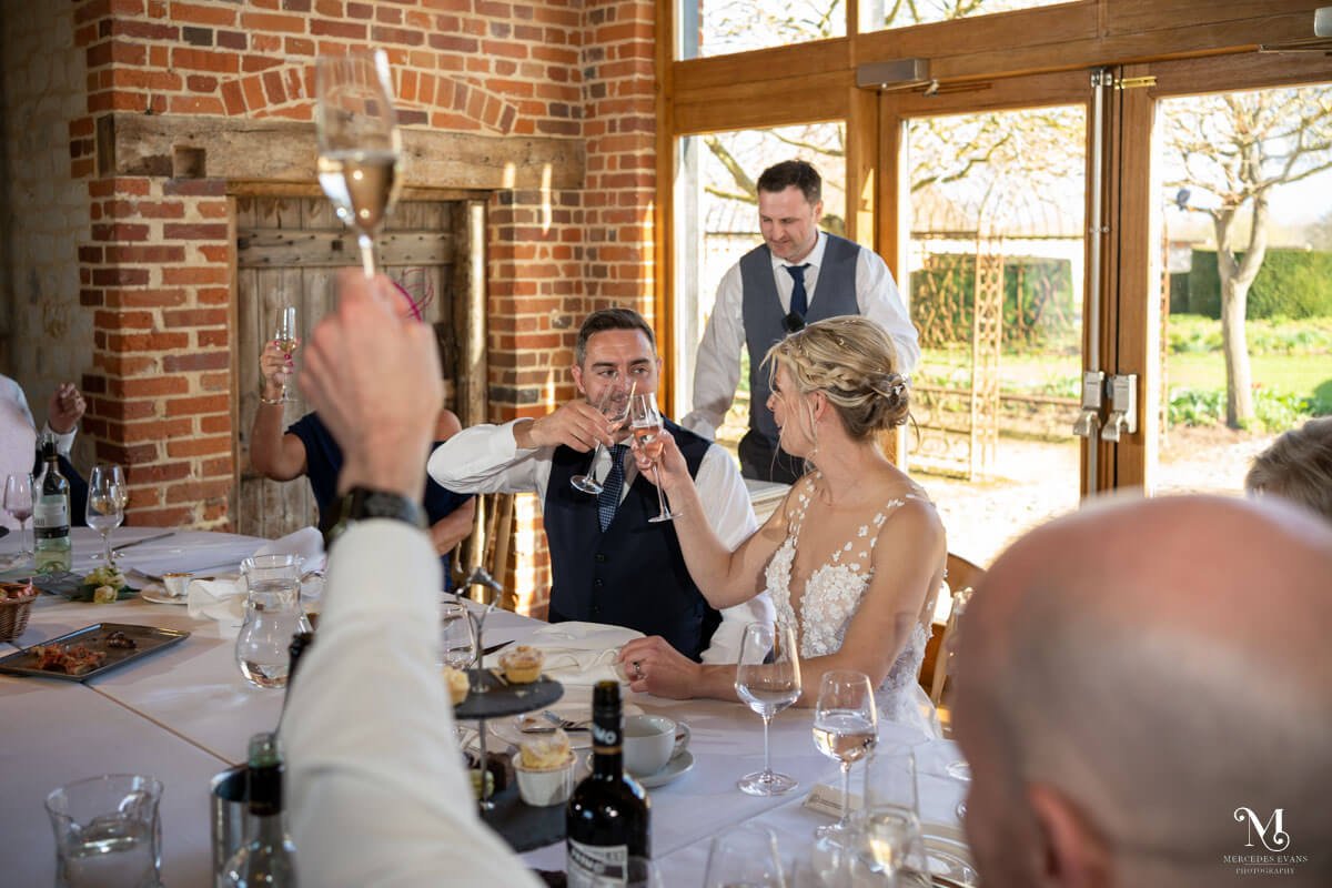 the bride and groom toast each other with champagne at the end of the best man's speech
