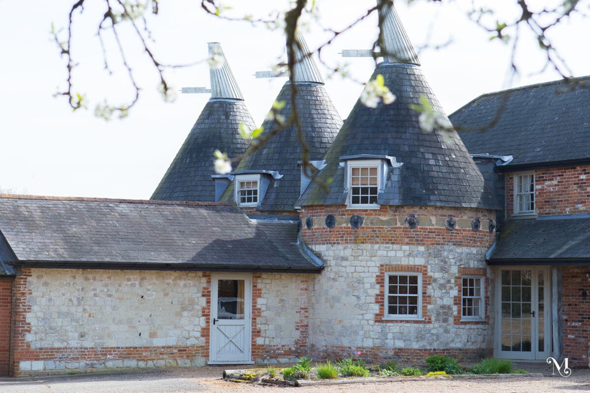 The Oast House at Bury Court Barn with white blossom