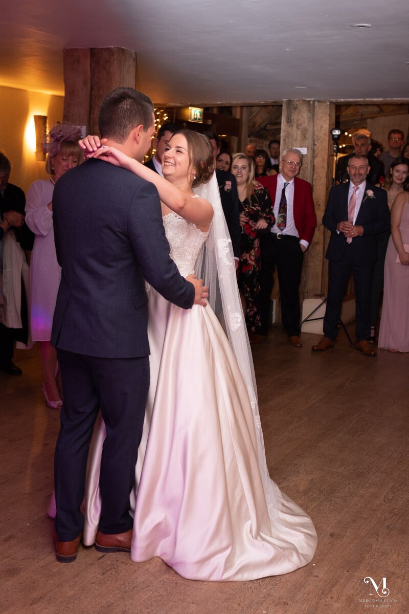 the bride and groom enjoy their first dance as their guests watch
