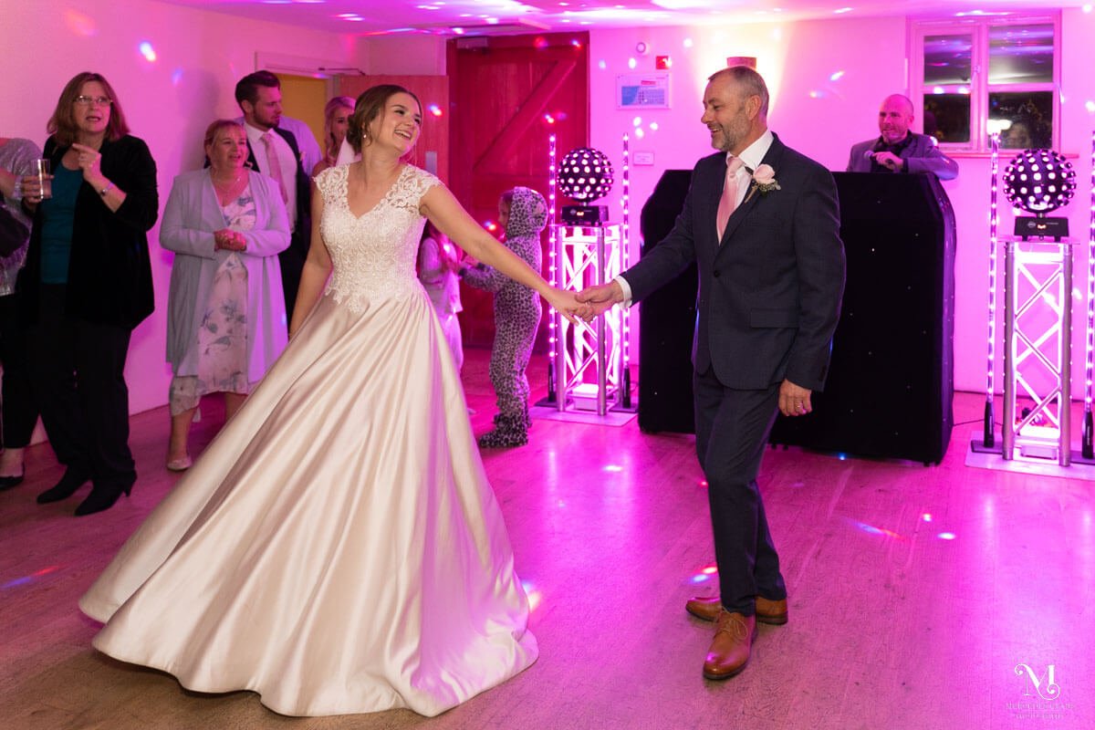 the bride and her father dance together and spin on the dancefloor