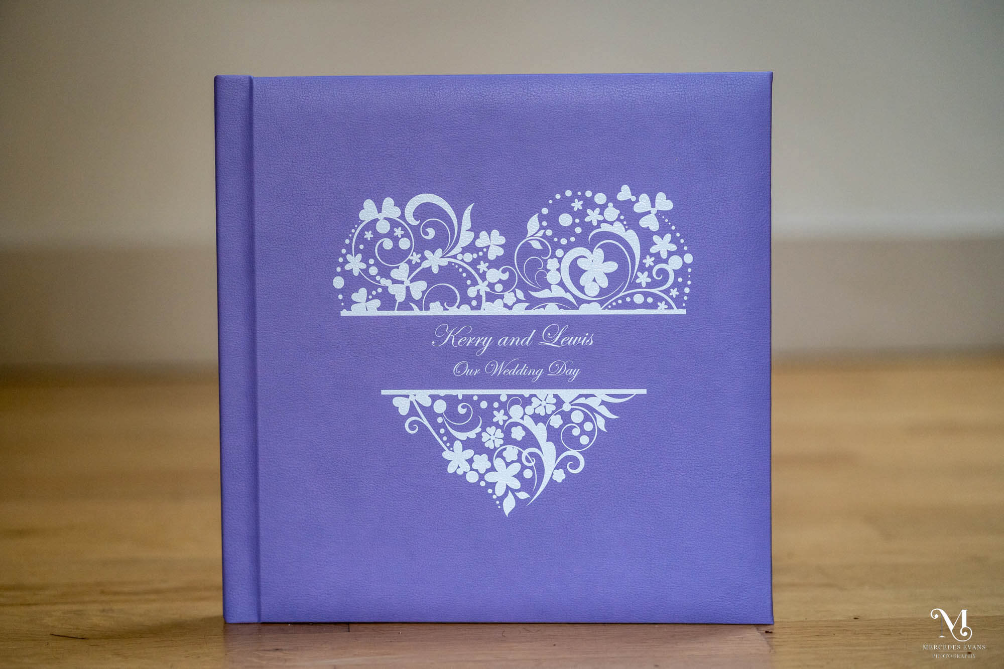 lilac wedding album with a floral heart and the words kerry and lewis our wedding day