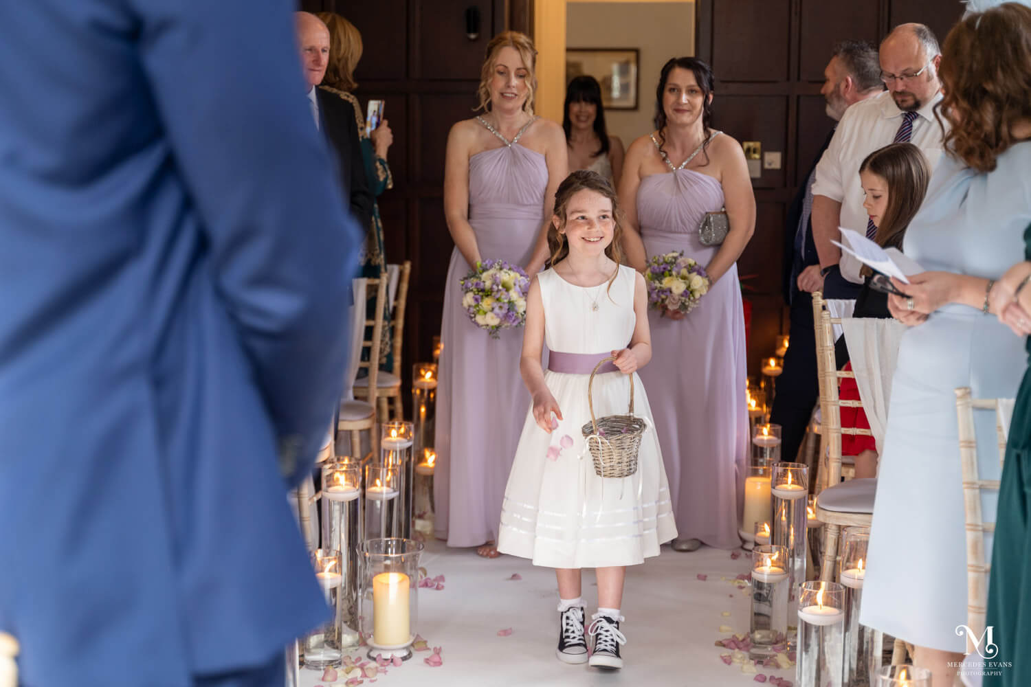 the flower girl scatters petals and the bridesmaids walk behind her