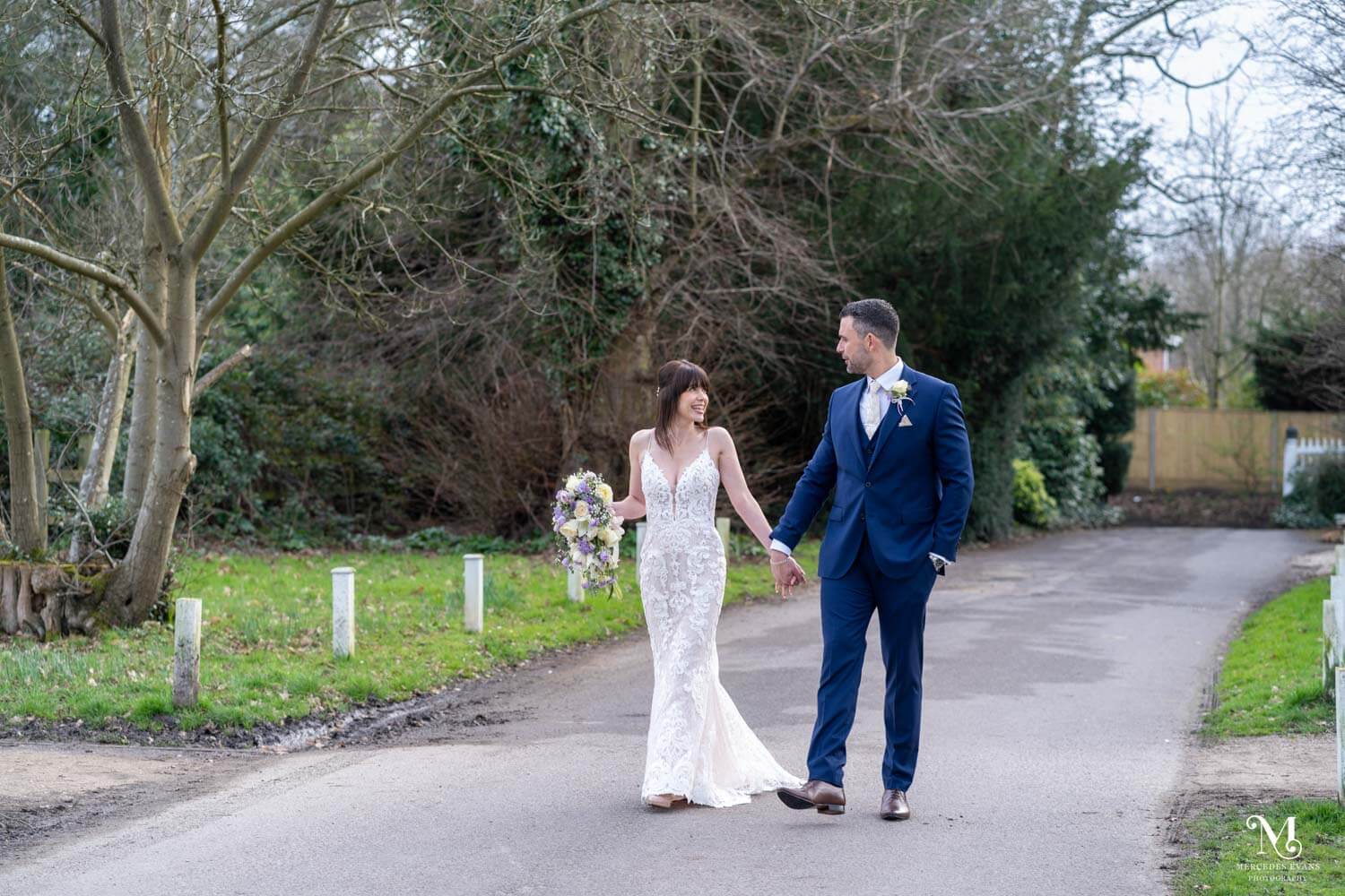 The bride and groom walk hand in hand down the drive at cantley house hotel