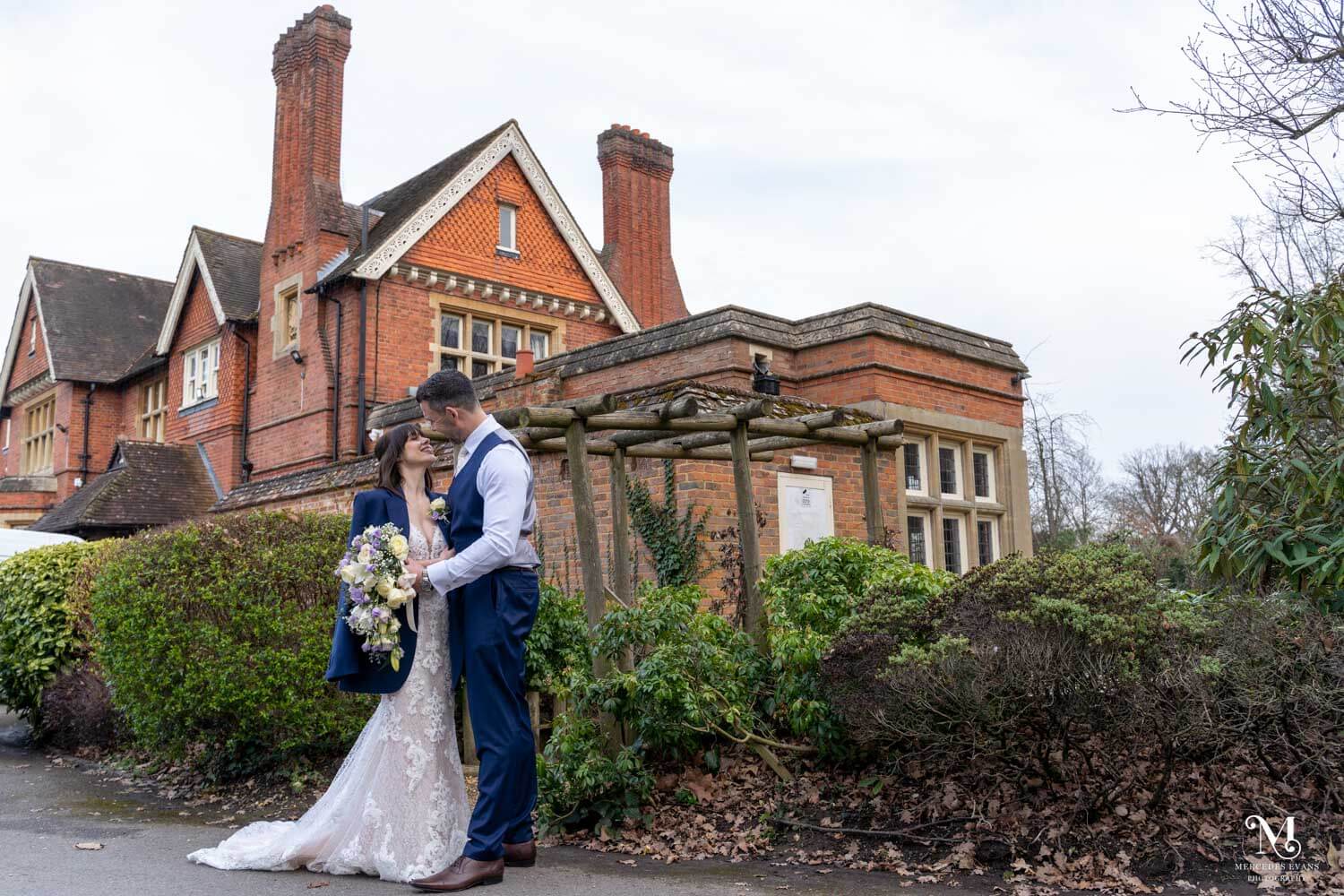 The bride and groom stand together in front of Cantley House