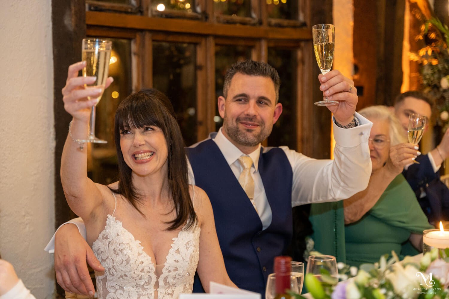 the bride and groom raise a toast during the wedding speeches