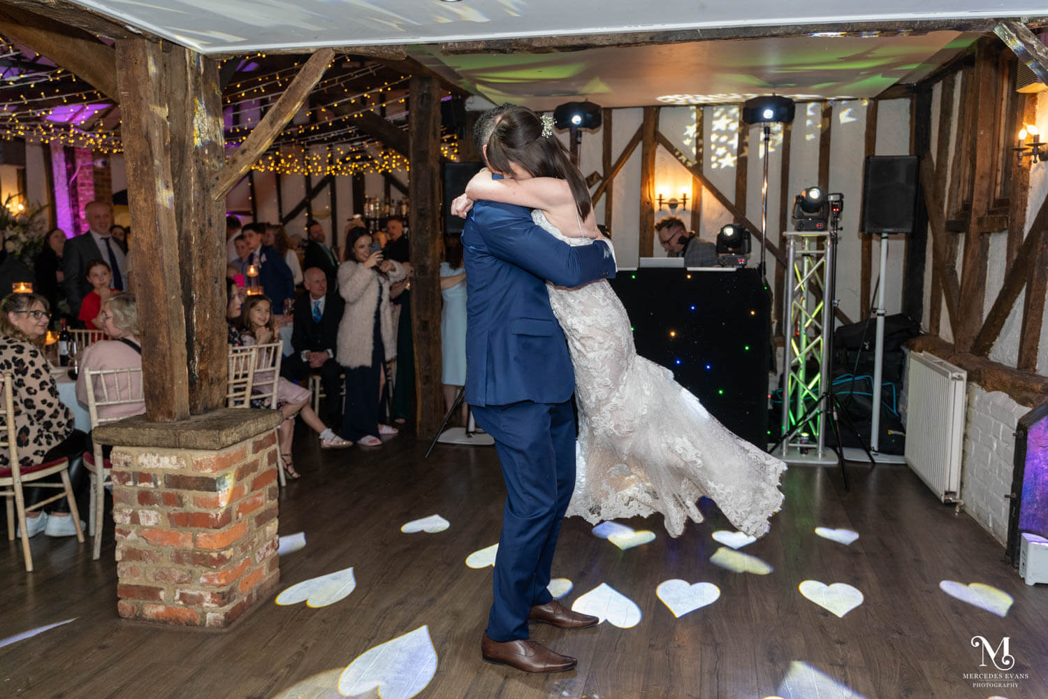 the groom swings his wife round on the dance floor during the first dance
